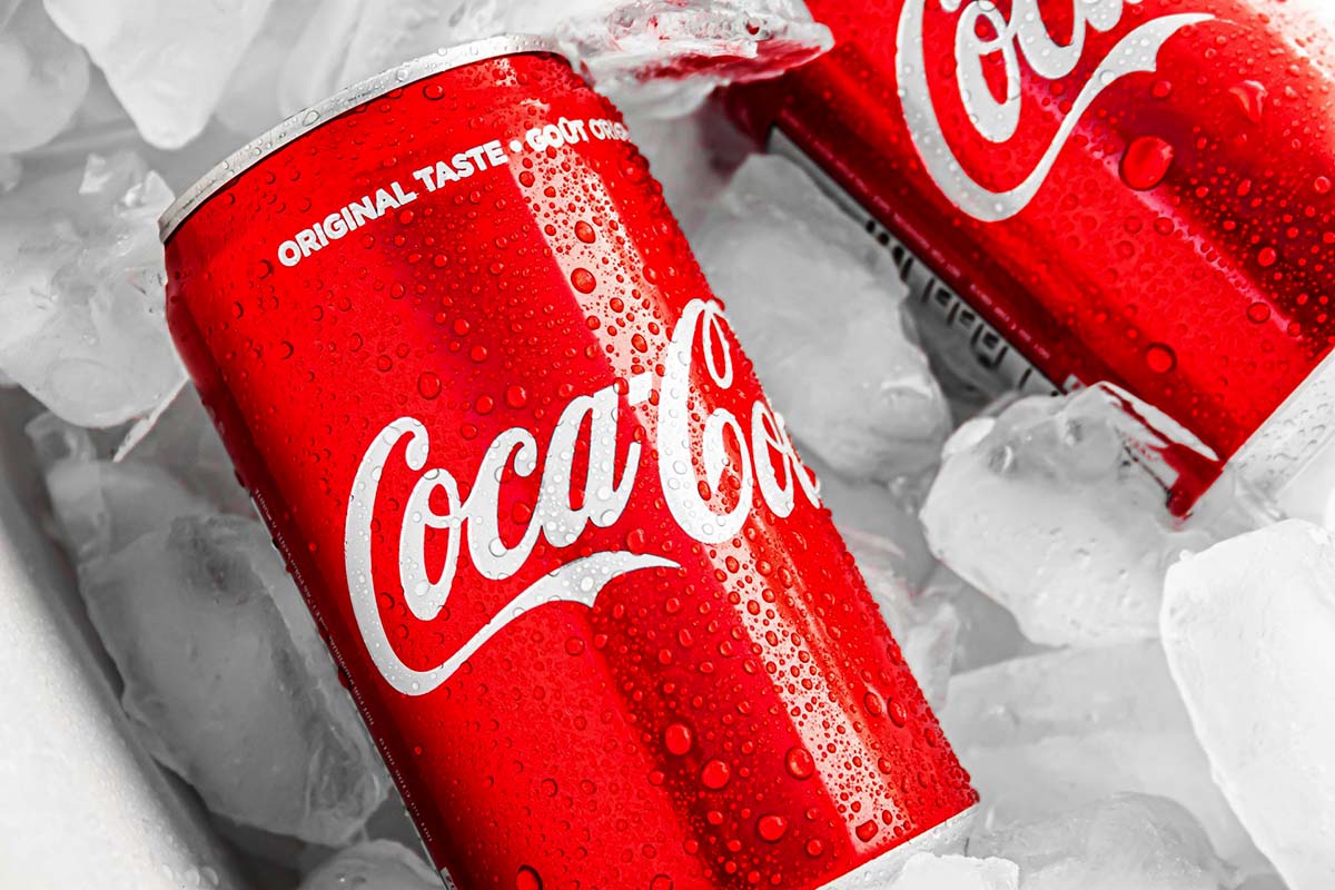 Twee blikjes Coca-Cola tussen het ijs, het beeld bij merken die submerken schrappen en inzetten op een simpel, herkenbaar product