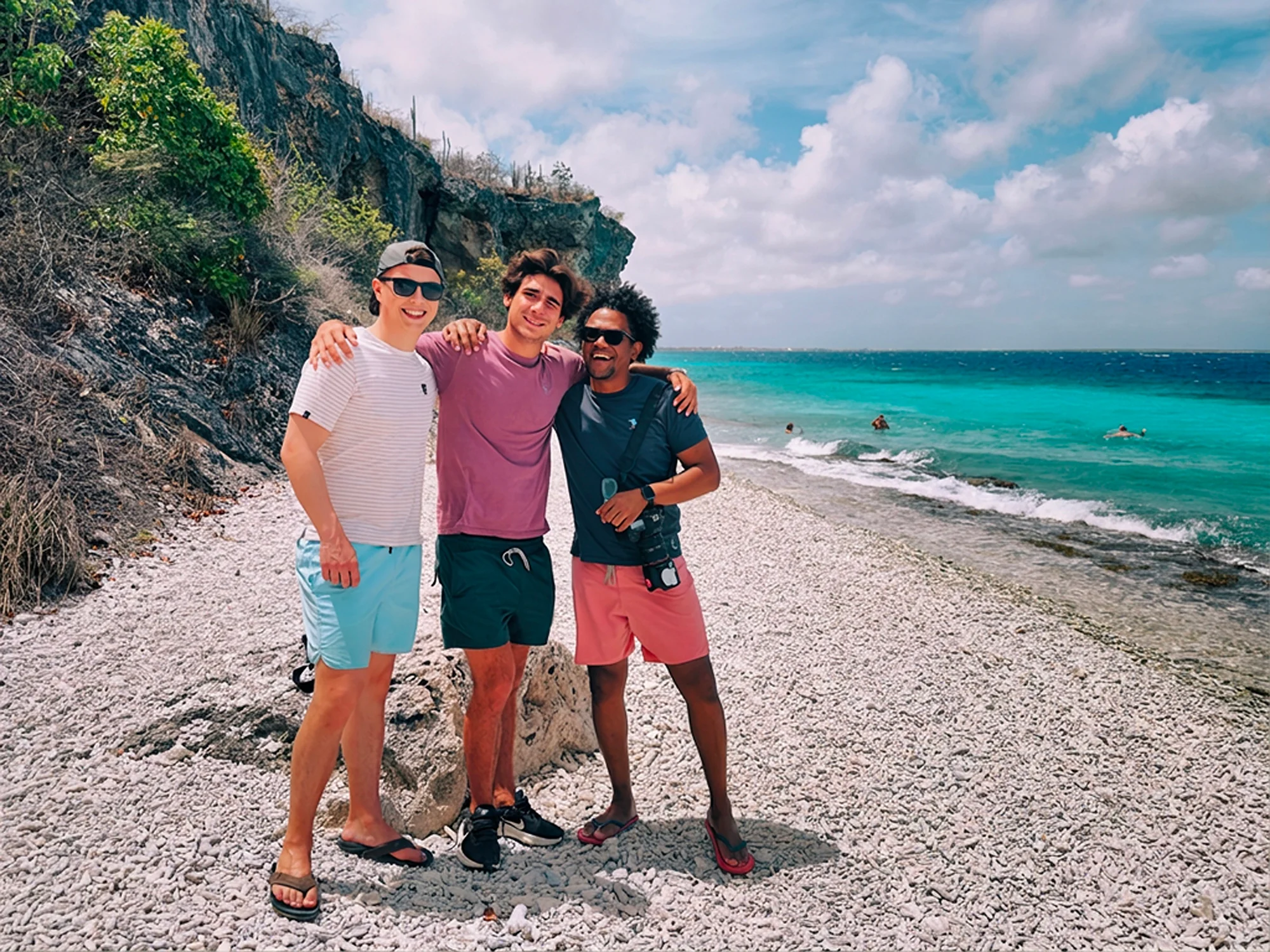 Drie mensen op het strand van Bonaire, het beeld naast de tekst over de drie waarden die in dit merk samenkomen: ecologie, luxe en natuurbehoud